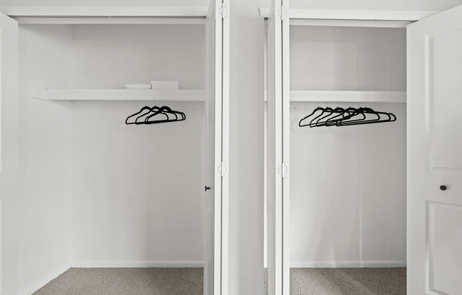 A white closet with two doors and a shelf.