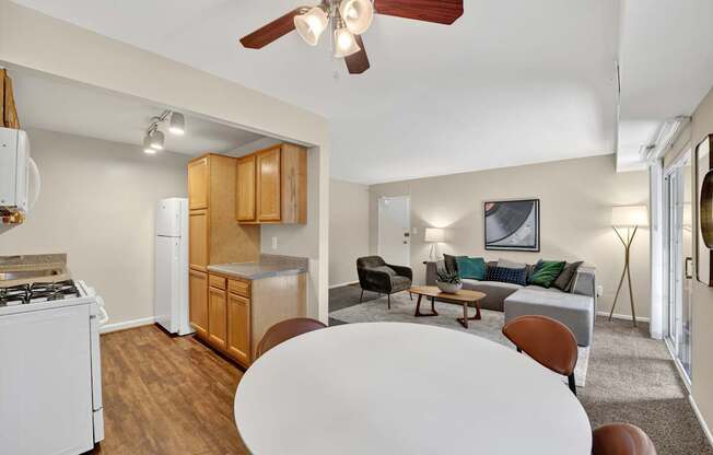 A living room with a white table and brown chairs.