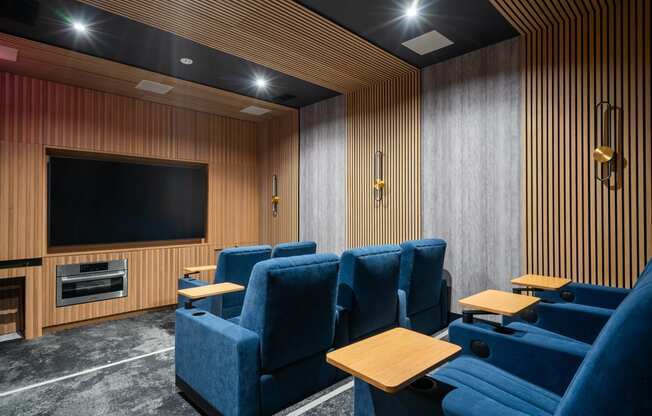 a cinema room with blue chairs and a television