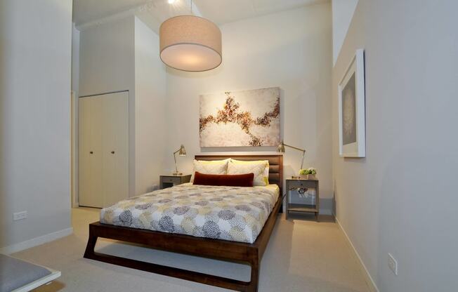 a bedroom with a bed and a painting on the wall