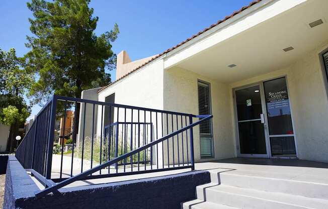 A house with a white wall and a black railing.