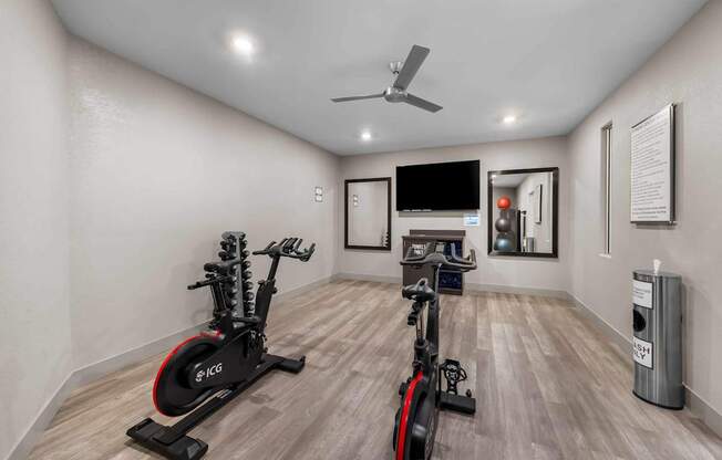 A room with a stationary bike and a treadmill.