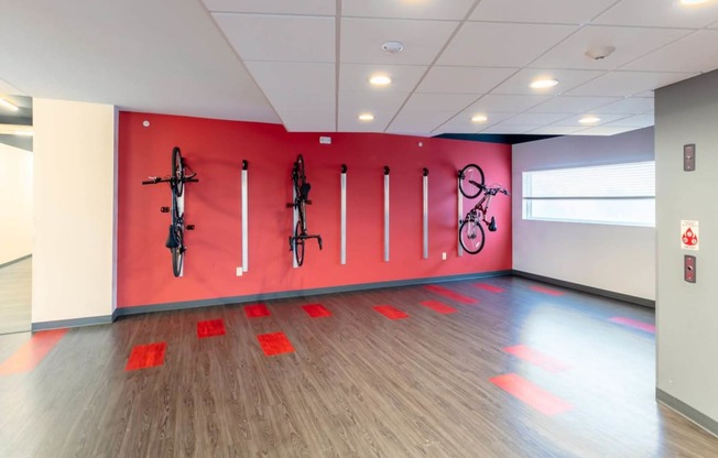 a room with a red wall with bikes on it