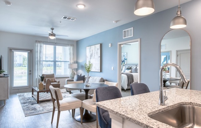 a living room and dining room with a kitchen and a sink