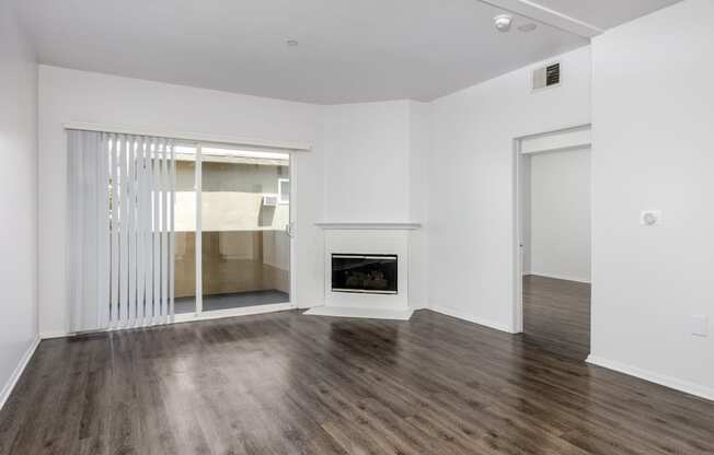 an empty living room with white walls and a fireplace