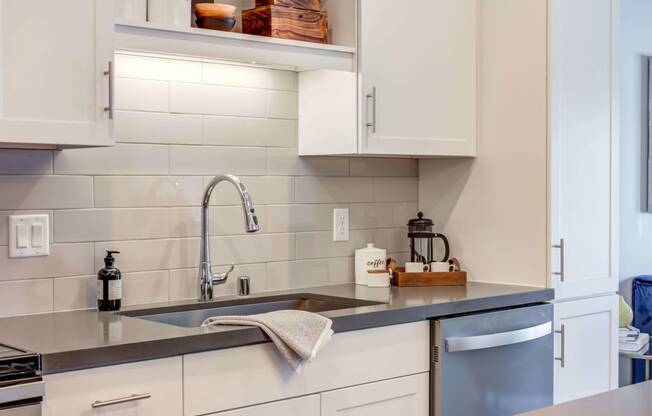 Bright kitchen with white cabinetry and Cesar Stone Quartz countertops.