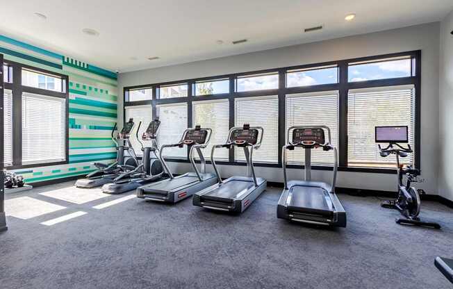 A room with treadmills and exercise bikes.