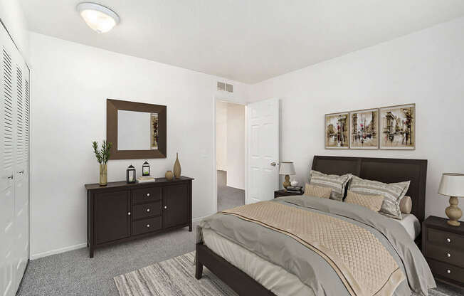 A bedroom with a bed, dresser, and mirror at Newport Village Apartments in Portage, MI