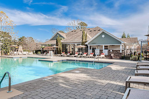 A large swimming pool with a house in the background.