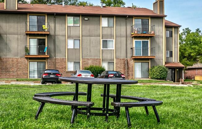 a table and two chairs in front of an apartment building