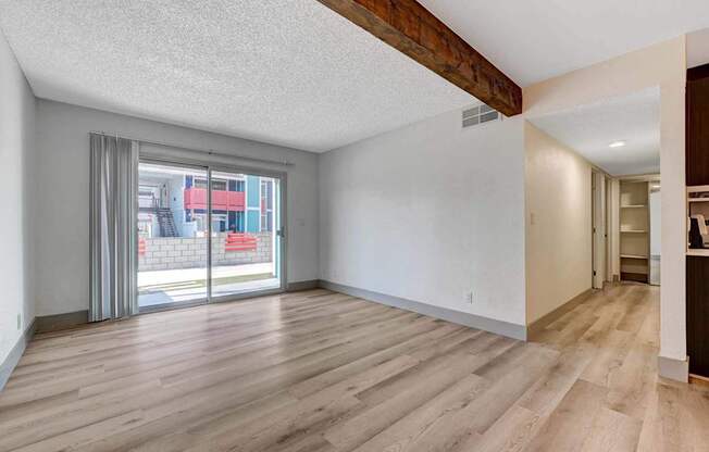 A room with wooden flooring and a sliding glass door.