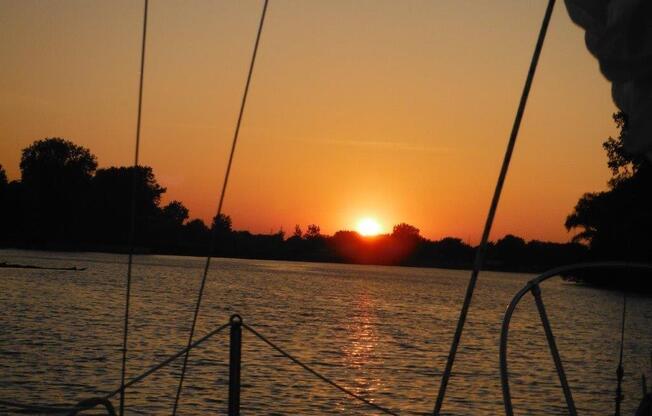 a sunset over a body of water with trees in the background