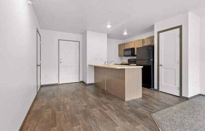A kitchen with a wooden floor and white walls.