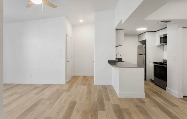 A kitchen with a white counter and black appliances.