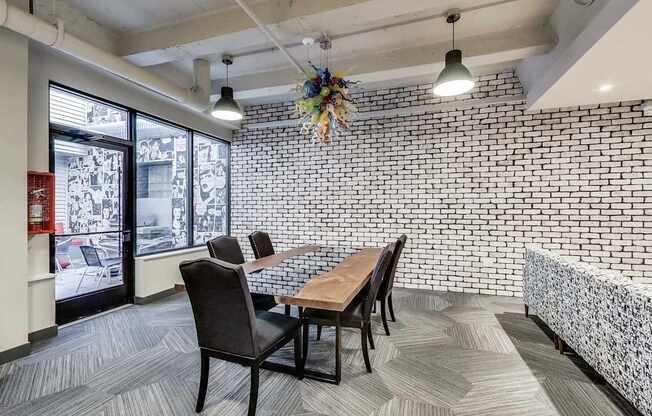a dining room with a table and chairs and a brick wall
