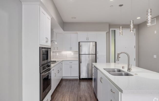 a kitchen with white cabinets and stainless steel appliances