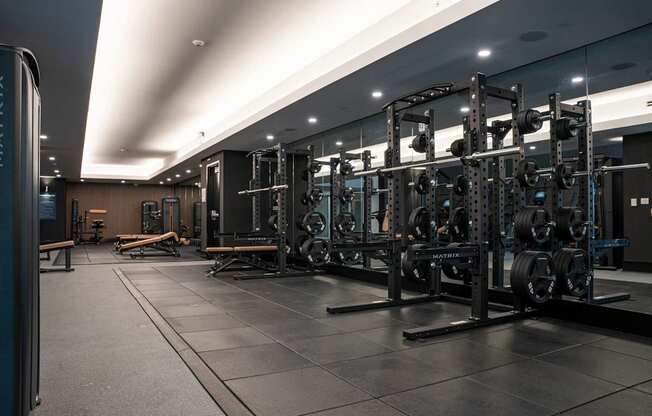 A gym with a variety of weightlifting equipment.
