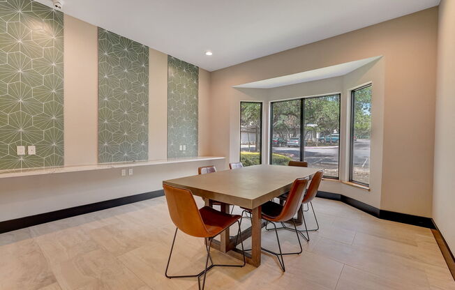 a dining room with a table and chairs and large windows