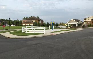 a street corner with houses and a white fence