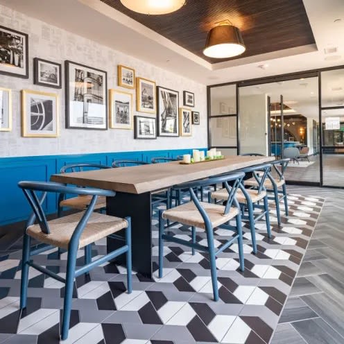 a communal table and chairs in a restaurant with a checkered floor