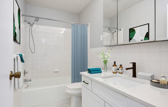 Laurel West End Apartments in Golden Valley, MN photo of a bathroom with white tiles and a blue shower curtain