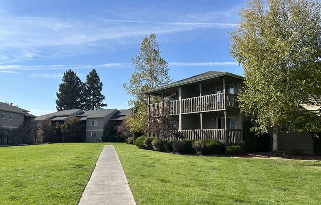 a grassy area with an apartment complex in the background