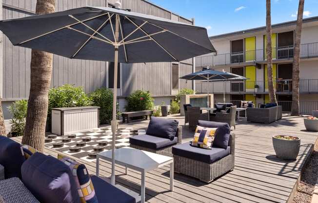 a patio with couches and chairs and umbrellas