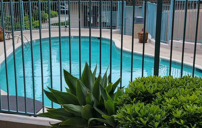 View from back building entry towards front of complex with swimming pool, leasing office and front buildings in background at La Mesa Village Apartments in La Mesa, California.