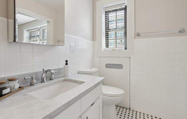 a white bathroom with a black and white checkered floor