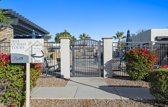 a gate with a sign that says self guided tours in front of a building