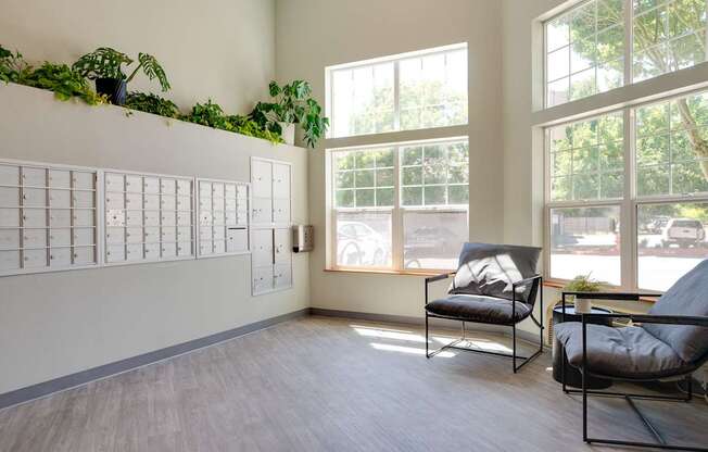 A room with a white wall, a window, and two chairs.