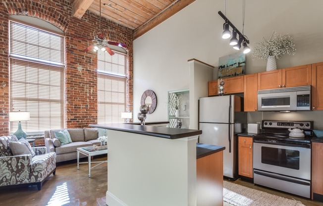 View of Kitchen, Showing Stainless Steel Appliances, Breakfast Bar, and View of Living Room at Alpha Mill Apartments