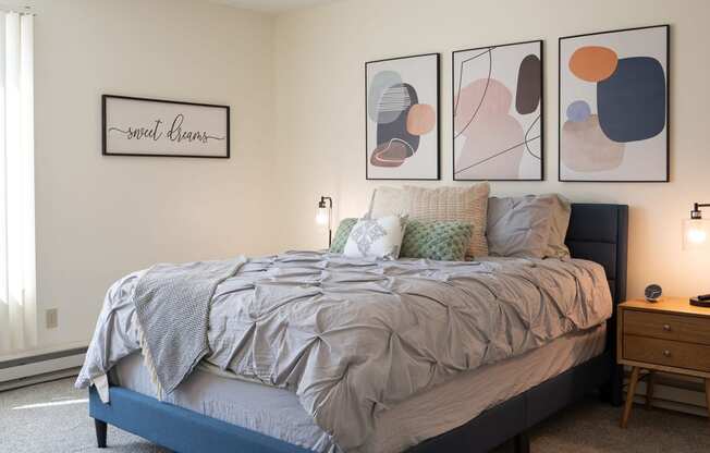 a bedroom with a bed and pictures on the wall