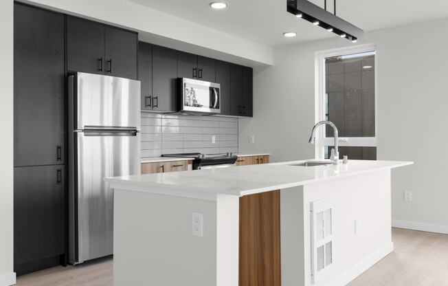 a kitchen with an island and stainless steel appliances at Ion Town Center, Washington, 98133