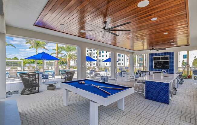 a pool table in a covered patio with tables and chairs at Altis Santa Barbara, Florida