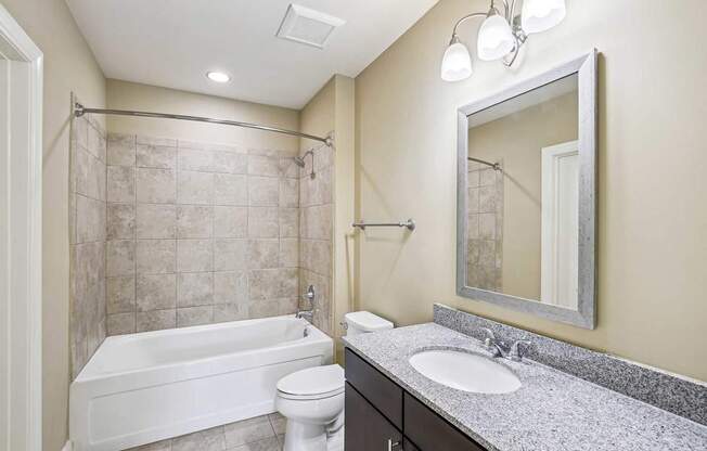 A bathroom with a white tub, toilet, and sink.