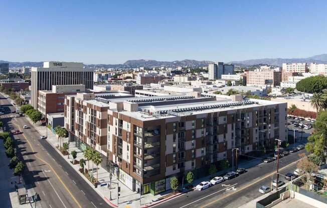A city street with apartment buildings and cars.