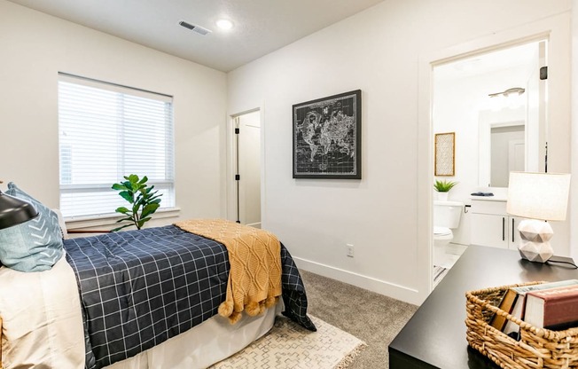 a bedroom with a bed and an open door leading to a bathroom