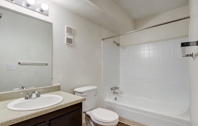 A white bathroom with a sink, toilet, and bathtub.