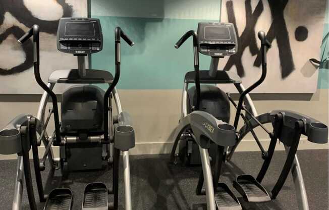 a gym with several exercise bikes and a tv