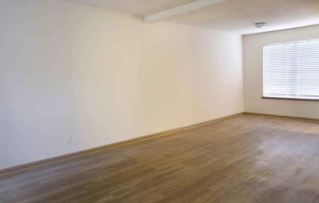 a bedroom with hardwood floors and a large window