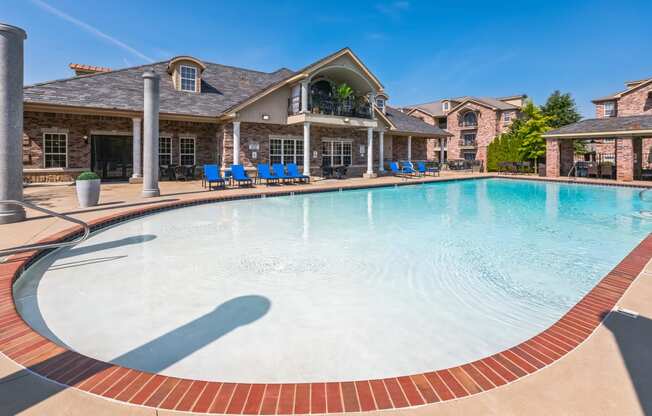 a large swimming pool with a house in the background