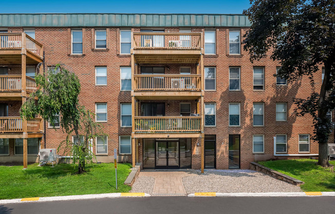 an exterior view of a brick apartment building with balconies at COVE West Hartford, West Hartford, CT