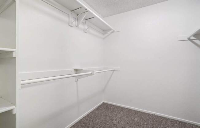 an empty room with white walls and a white closet