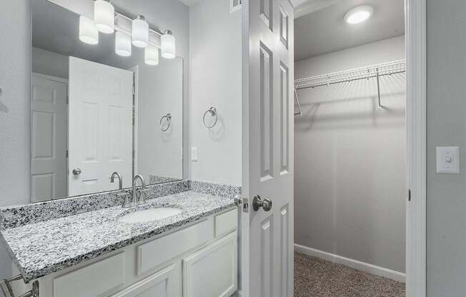 A bathroom with a granite countertop and a white door.