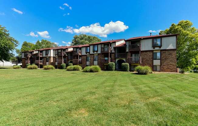 An apartment building with a green lawn in front at Old Monterey Apartments, Springfield, MO