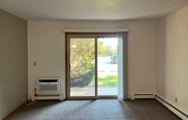 A room with a window and sliding glass door.