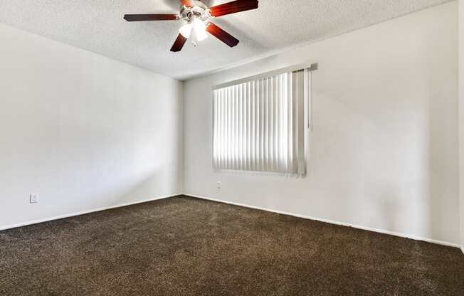 Bedroom with ceiling fan, carpeted flooring, vertical window coverings