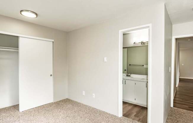 A white bathroom with a white door and a white cabinet.