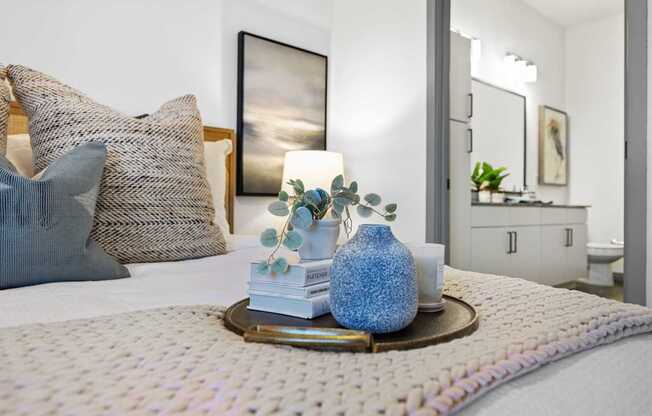 A bedroom with a bed, a mirror, and a painting on the wall.